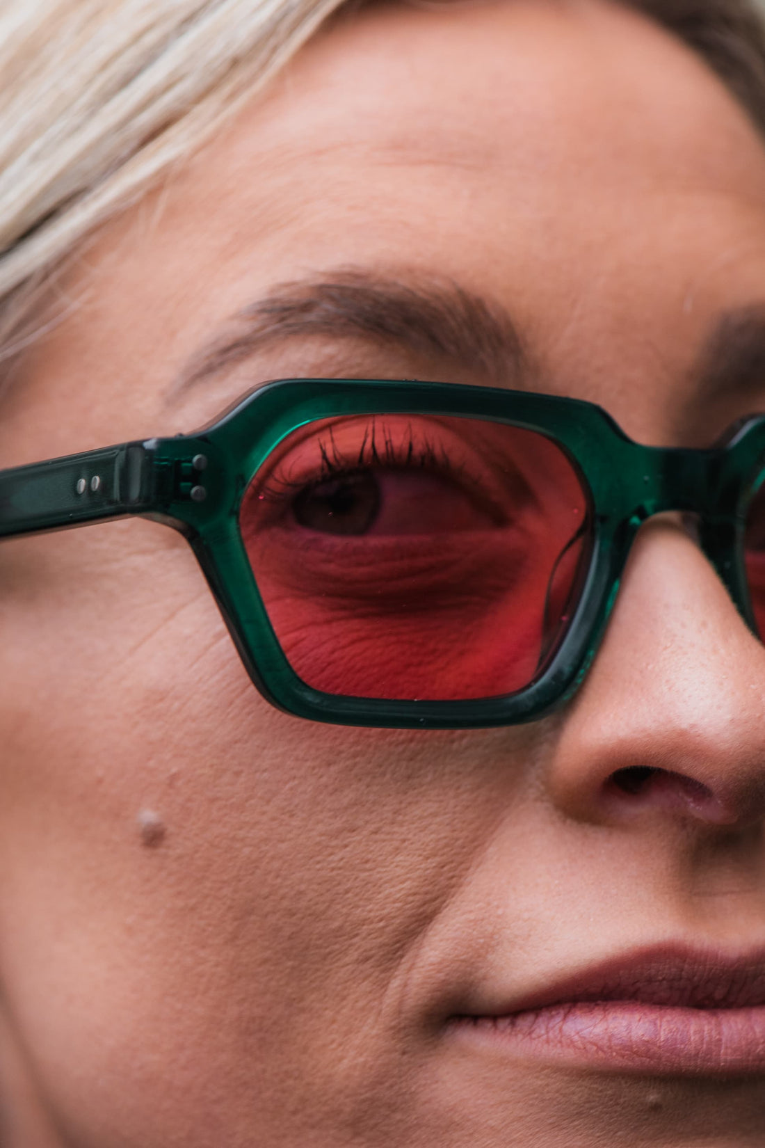 946 Clear Green Sunglasses with Pink Lenses, worn close up